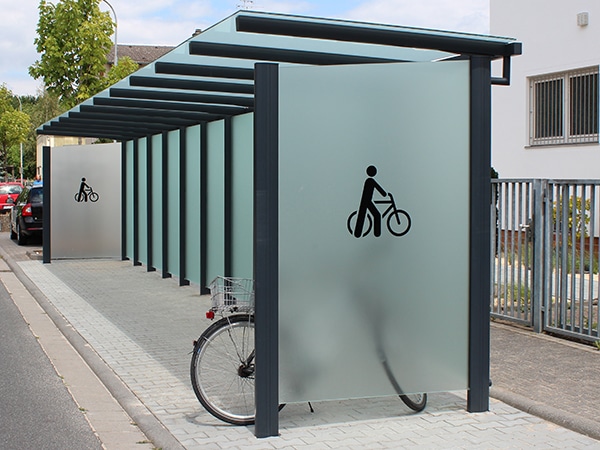 Eine Fahrradüberdachung mit undurchsichtigen Gläsern am Straßenrand