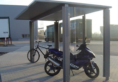 Eine Fahrradüberdachung am Straßenrand mit je einem Fahrrad und Motorrad