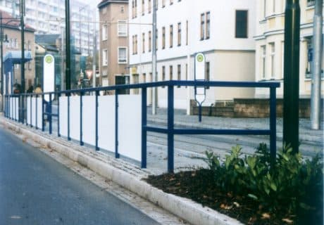 Eine Geländerreihe am Straßenrand mit Handlauf und Spritzschutz