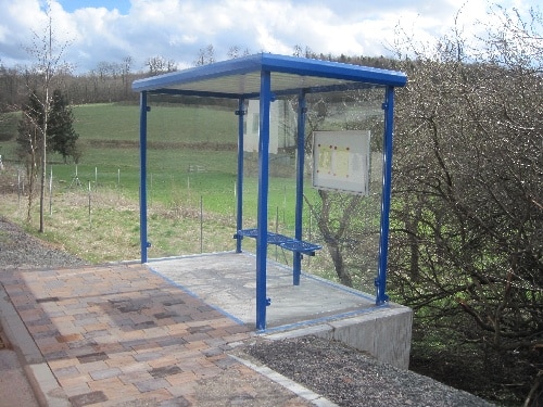 Eine blaue zweifeldrige Wartehalle am Wegesrand