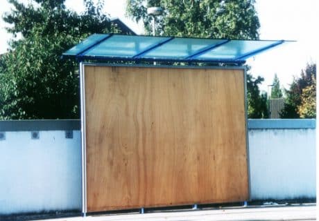 Eine Wartehalle mit einem Werbeplakat als Rückwand