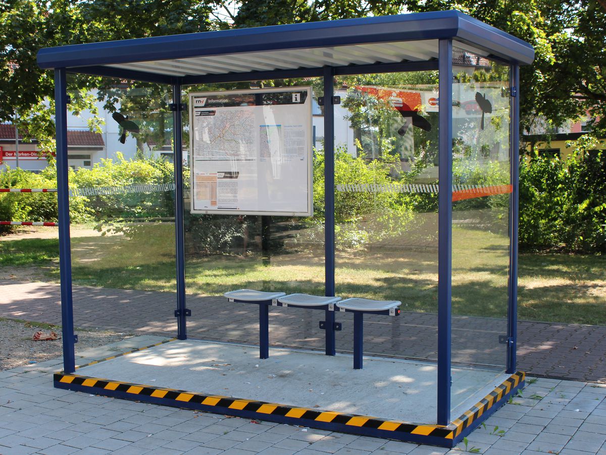 Ein blauer Raucherunterstand mit Bodenplatte am Wegesrand