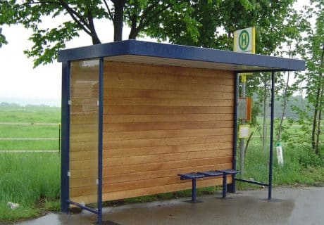 Eine Wartehalle mit Holzrückwand am Straßenrand