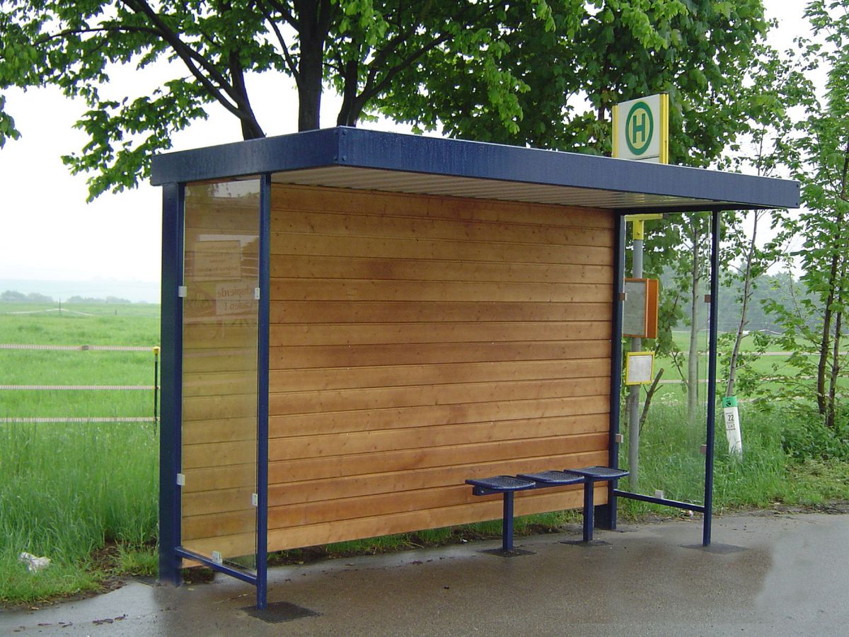 Eine Wartehalle mit Holzrückwand am Straßenrand