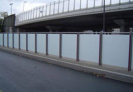 Eine Geländerreihe am Straßenrand mit undurchsichtigen Scheiben