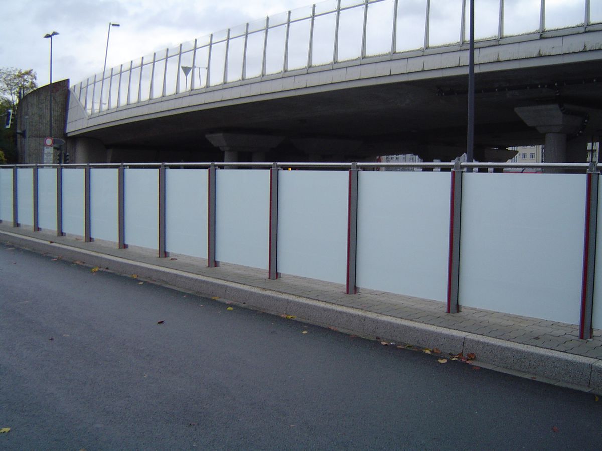 Eine Geländerreihe am Straßenrand mit undurchsichtigen Scheiben