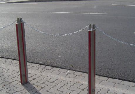 Eine Geländerreihe am Straßenrand mit Absperrkette und Feuerwehrverschluss