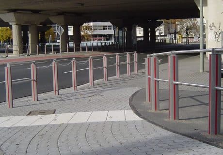 Eine Geländerreihe am Straßenrand mit Handlauf und Knieholm