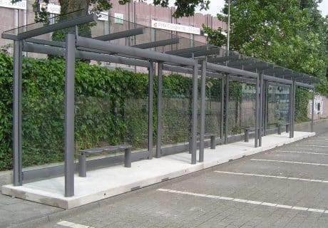 Eine graue dreifeldrige transportable Wartehalle mit oberflächenstrukturierter Betonbodenplatte