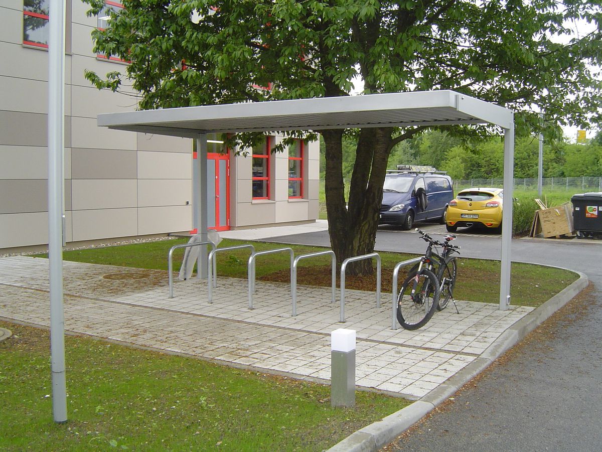 Eine Fahrradüberdachung mit mehreren Fahrradbügeln am Straßenrand