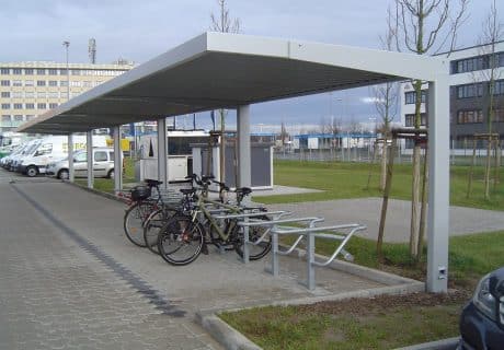 Eine Fahrradüberdachung mit mehreren Fahrradbügeln am Wegesrand
