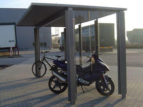 Eine Fahrradüberdachung am Straßenrand mit je einem Fahrrad und Motorrad