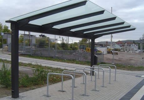 Eine Fahrradüberdachung mit mehreren Fahrradanlehnbügeln am Wegesrand