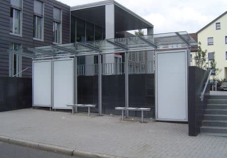 Eine graue sechsfeldrige Wartehalle mit Werbevitrinen in der Rückwand