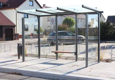 Eine graue dreifeldrige Wartehalle mit Sitzbank am Straßenrand
