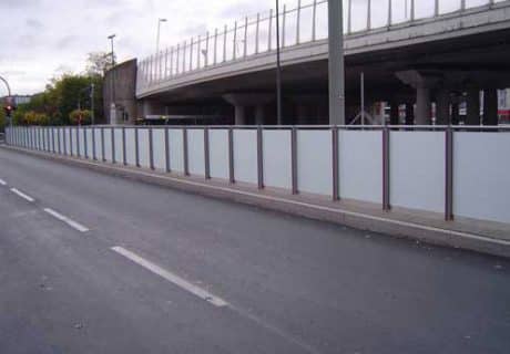 Eine Geländerreihe mit undurchsichtigen Scheiben am Straßenrand