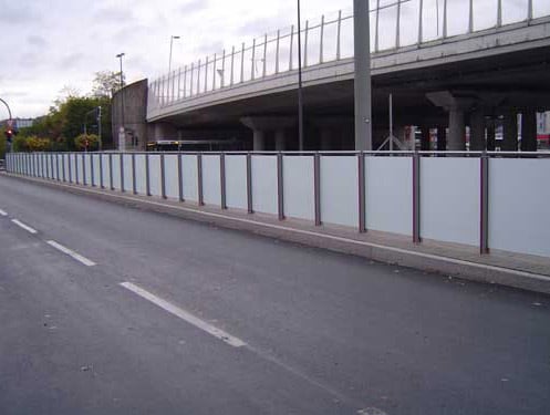 Eine Geländerreihe mit undurchsichtigen Scheiben am Straßenrand