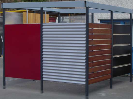 Eine Holz- und Metallumhausung für Mülleimer neben einem Gebäude