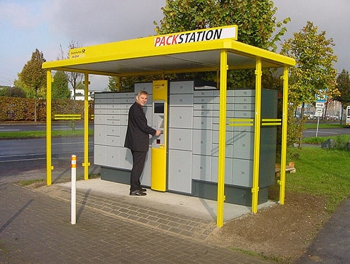 Eine Person steht an einer überdachten Packstation der Deutschen Post