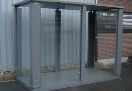 Eine graue Wartehalle vor einer Metallwand