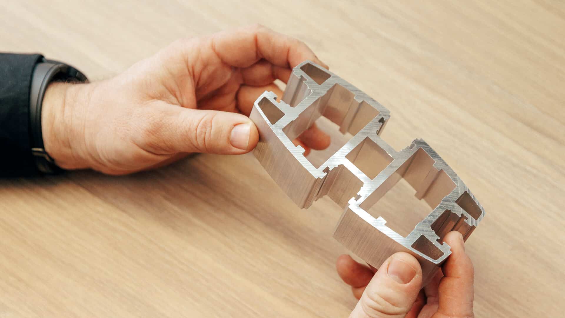 Zwei Hände halten ein Produktionsteil der Zimmermann Stadtmöblierung